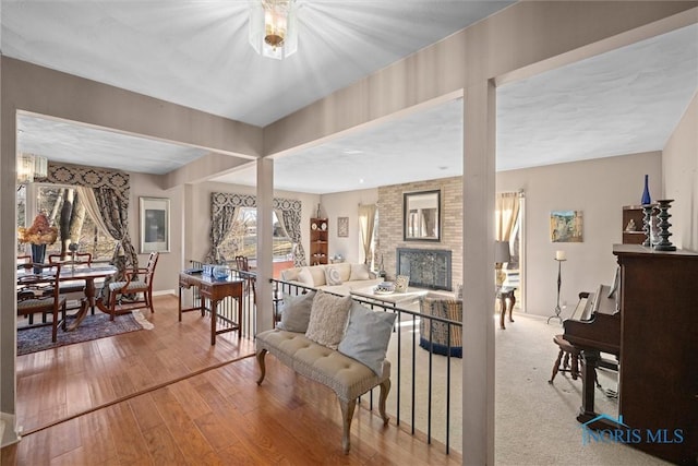 interior space featuring a brick fireplace, baseboards, and hardwood / wood-style floors