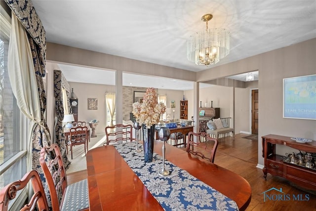 dining area featuring a notable chandelier, wood finished floors, and baseboards