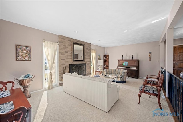 living room with baseboards, a large fireplace, and light colored carpet