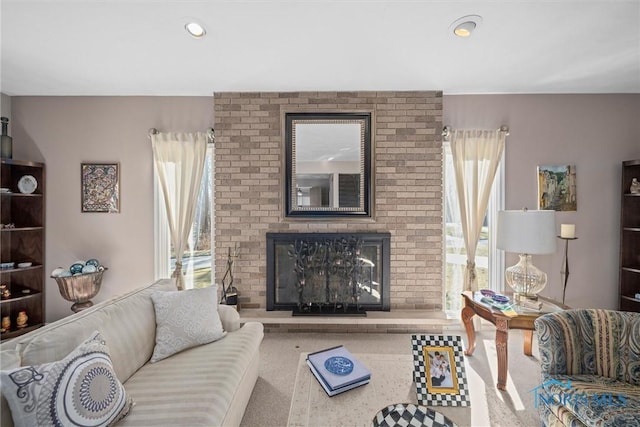 living area with a brick fireplace, carpet flooring, and recessed lighting