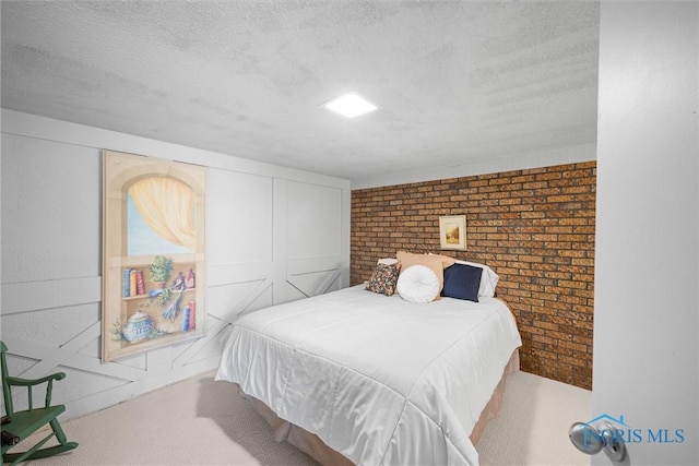 carpeted bedroom with a closet, brick wall, and a textured ceiling