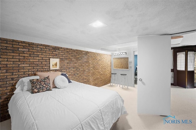 bedroom with carpet flooring, brick wall, and a textured ceiling