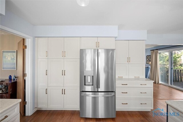 2944 Plumbrook Dr, Maumee, OH 43537 - kitchen with stainless steel fridge, white cabinetry, dark wood-type flooring, and light stone counters