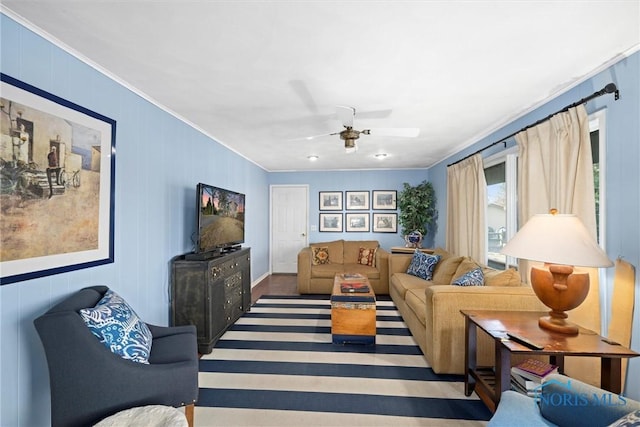 living room with a ceiling fan and crown molding