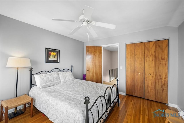 bedroom with a closet, a ceiling fan, baseboards, and wood finished floors