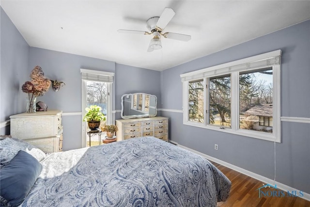 bedroom featuring ceiling fan, baseboards, and wood finished floors