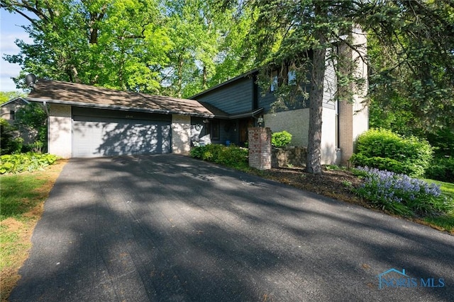 2944 Plumbrook Dr, Maumee, OH 43537 - view of front of property featuring brick siding, driveway, and a garage