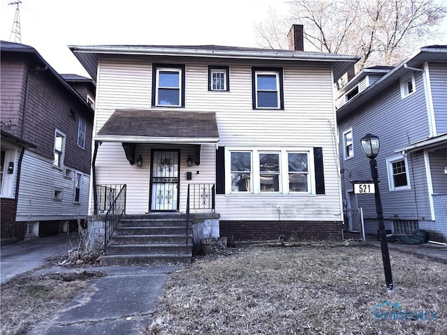 view of front of home featuring covered porch and a chimney