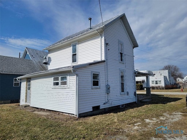 rear view of house featuring a yard