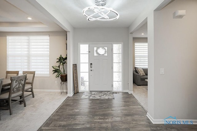 entrance foyer featuring plenty of natural light, wood finished floors, baseboards, and a chandelier