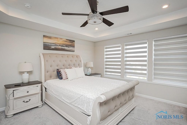 bedroom featuring baseboards, visible vents, recessed lighting, a raised ceiling, and light colored carpet