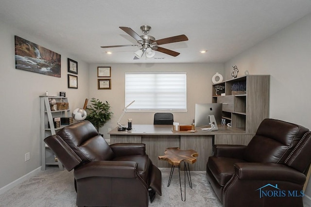 office area featuring baseboards, light colored carpet, and ceiling fan