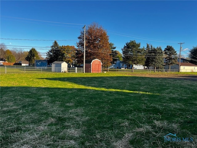 view of yard featuring an outdoor structure and fence