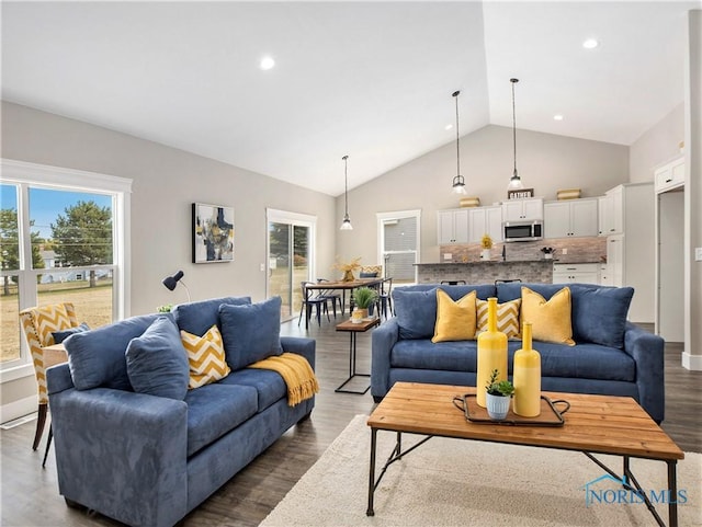 living room with recessed lighting, plenty of natural light, high vaulted ceiling, and wood finished floors