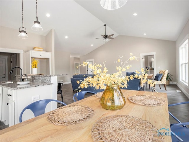 dining space with baseboards, dark wood finished floors, a ceiling fan, and vaulted ceiling