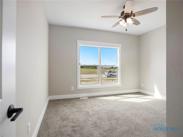 spare room featuring baseboards, carpet, and ceiling fan