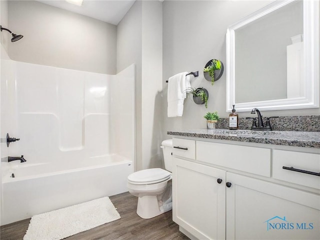 bathroom featuring vanity, shower / bathing tub combination, toilet, and wood finished floors