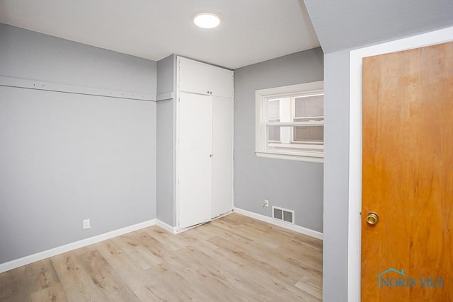 unfurnished bedroom featuring visible vents, baseboards, and light wood finished floors