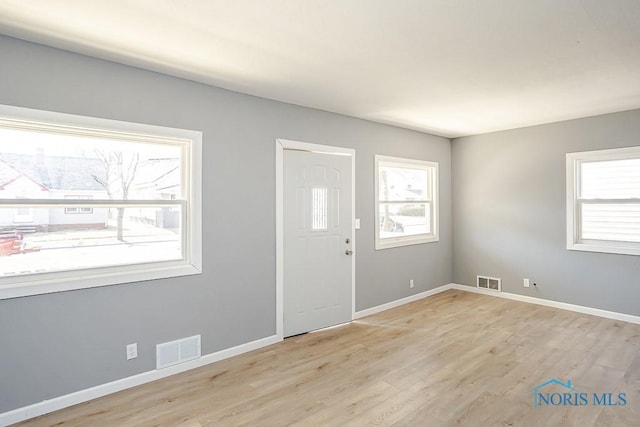 entryway with wood finished floors, visible vents, and baseboards