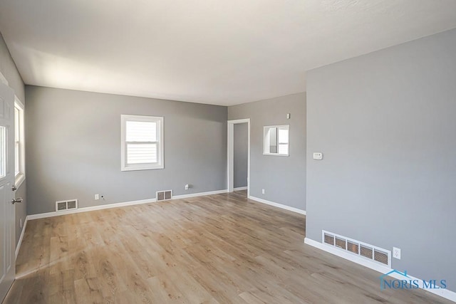 spare room featuring light wood-style flooring and visible vents