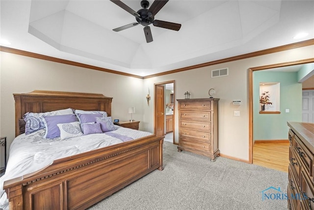 bedroom featuring visible vents, ornamental molding, a tray ceiling, and light colored carpet