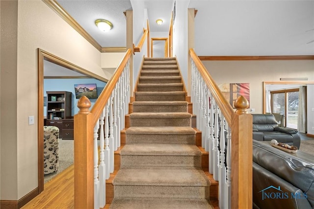 stairs featuring crown molding, baseboards, and wood finished floors