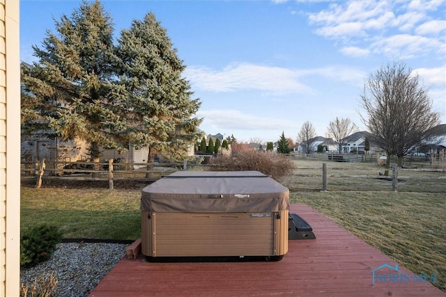 wooden deck with a hot tub, a yard, and fence