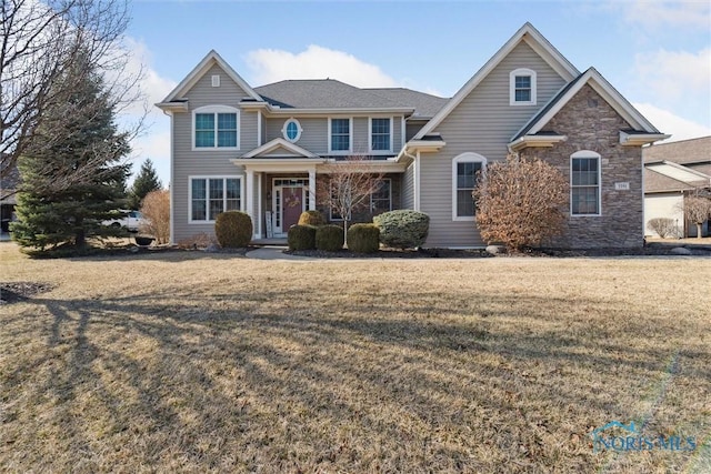 view of front of property featuring stone siding and a front yard