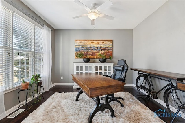 office area with wood finished floors, baseboards, visible vents, and ceiling fan