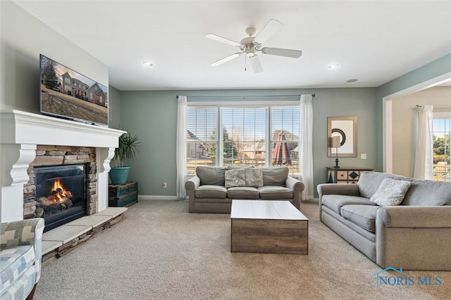 living room with carpet, a ceiling fan, baseboards, recessed lighting, and a stone fireplace