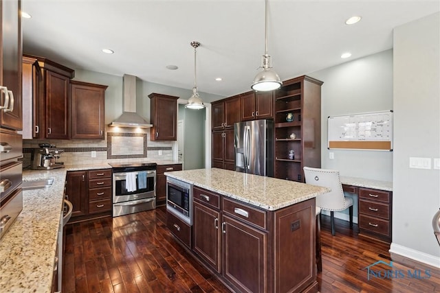 kitchen with dark wood-style floors, appliances with stainless steel finishes, wall chimney range hood, tasteful backsplash, and a center island