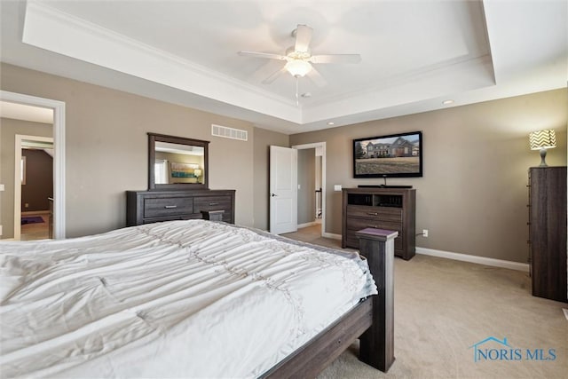 bedroom with visible vents, baseboards, light colored carpet, a raised ceiling, and a ceiling fan