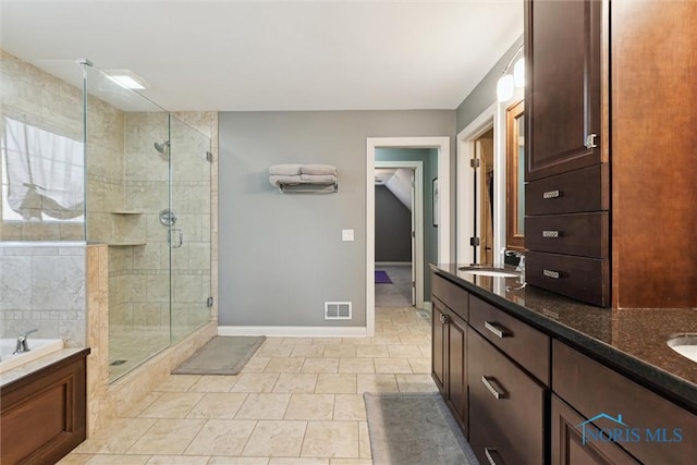 bathroom featuring a stall shower, a bath, visible vents, and a sink