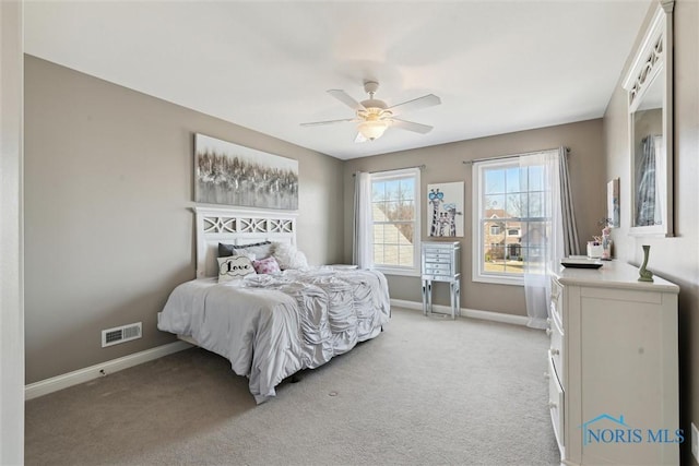 bedroom featuring visible vents, baseboards, light colored carpet, and a ceiling fan