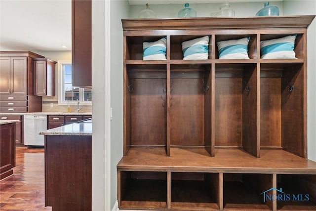 mudroom featuring wood finished floors and a sink