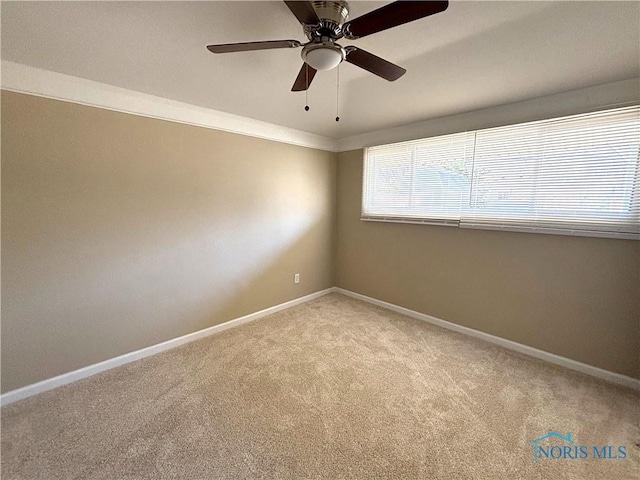 unfurnished room featuring baseboards, light colored carpet, and ceiling fan