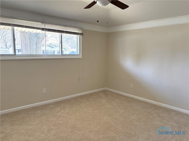 spare room featuring baseboards, ceiling fan, and carpet flooring