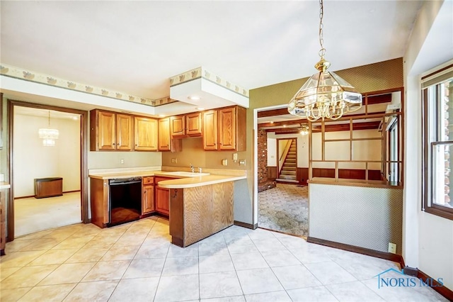 kitchen featuring dishwasher, light countertops, a peninsula, an inviting chandelier, and a sink