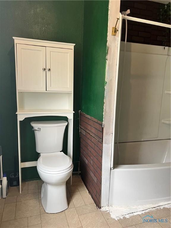 full bathroom with tile patterned floors, toilet, and washtub / shower combination