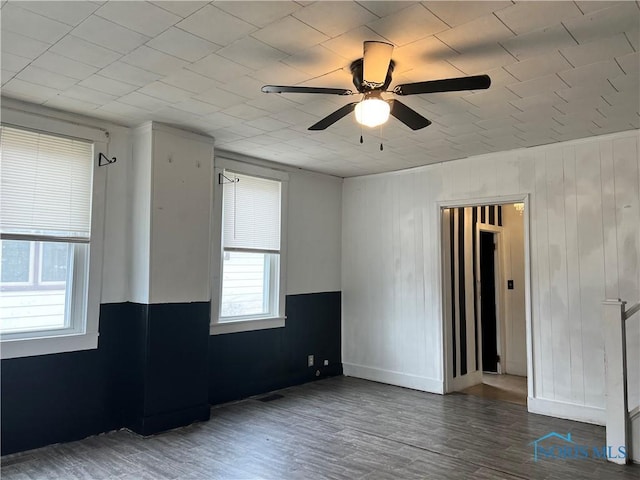 empty room with baseboards, a ceiling fan, and wood finished floors