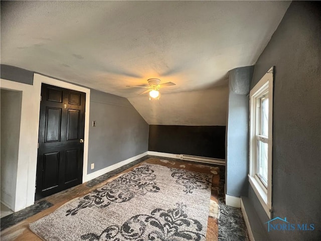 bonus room featuring vaulted ceiling, a ceiling fan, baseboards, and a textured ceiling