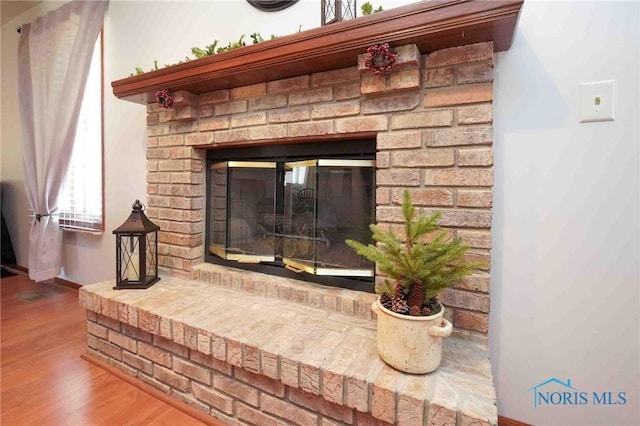 details with a fireplace, baseboards, and wood finished floors