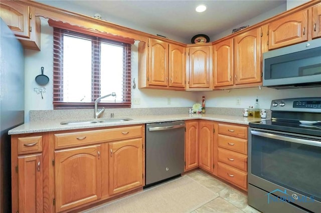 kitchen with a sink, stainless steel appliances, and light countertops