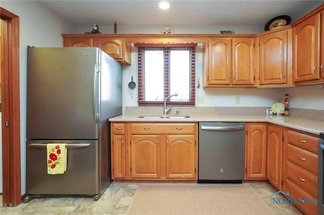 kitchen featuring a sink, stainless steel appliances, brown cabinetry, and light countertops