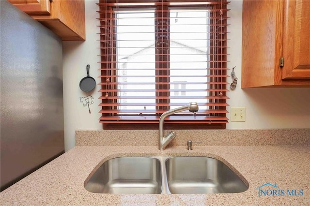 kitchen featuring light stone counters and a sink