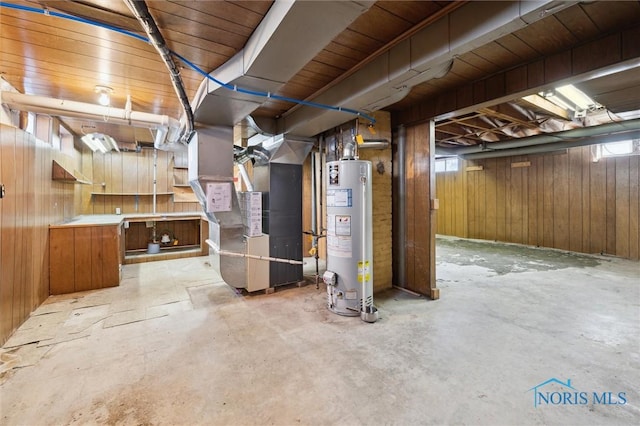 unfinished basement featuring gas water heater, heating unit, and wooden walls