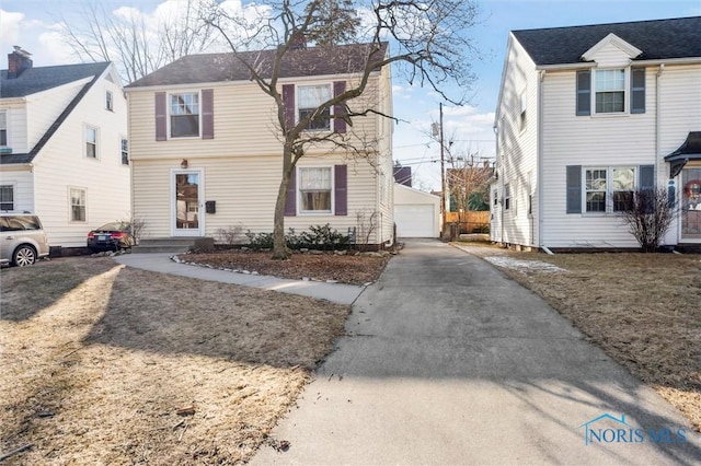 view of front of property with an outdoor structure and a detached garage