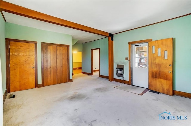 interior space with heating unit, beamed ceiling, and baseboards