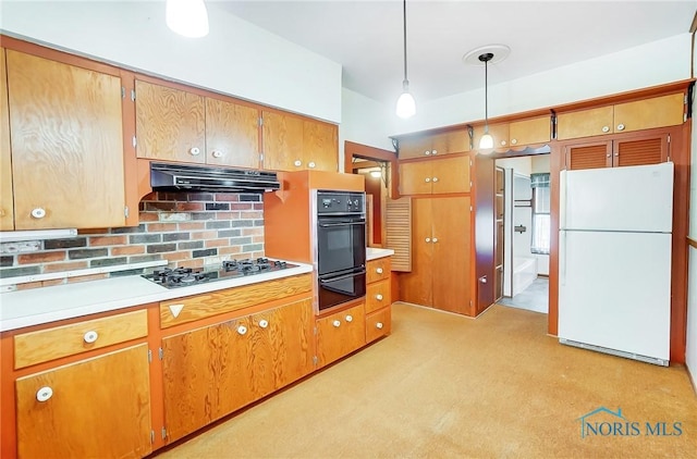 kitchen with a warming drawer, brown cabinets, black appliances, under cabinet range hood, and light countertops