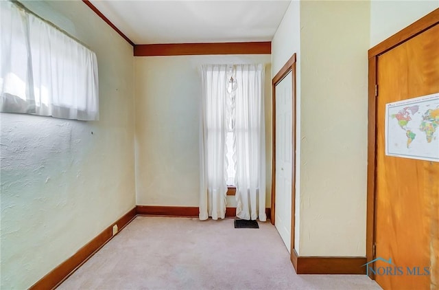 carpeted empty room with visible vents and baseboards